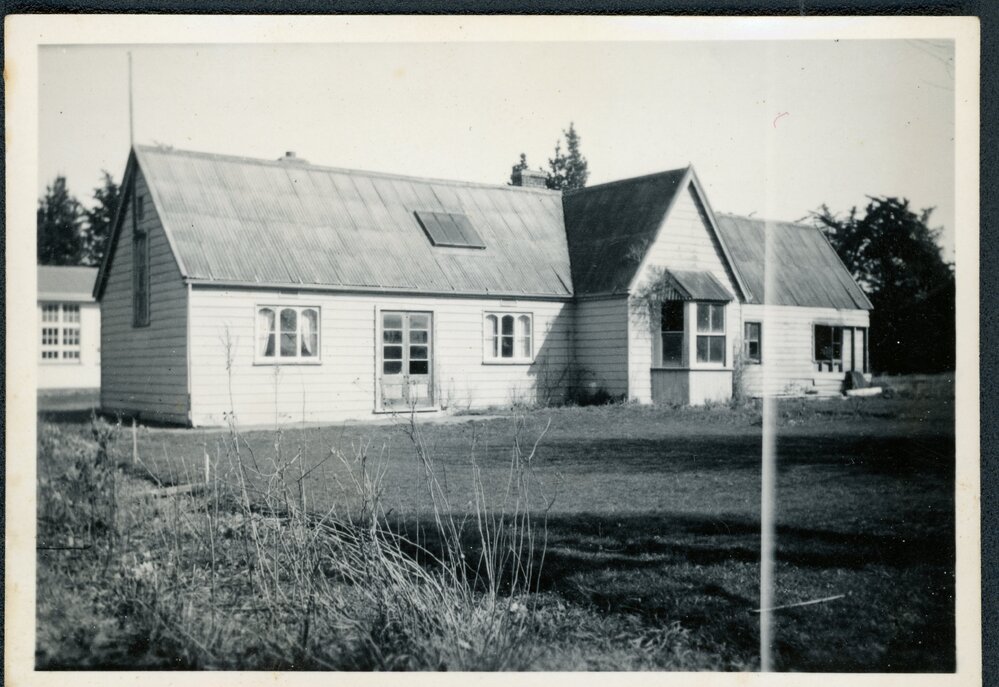 Old Courtenay School building with new school building in the background, 1956