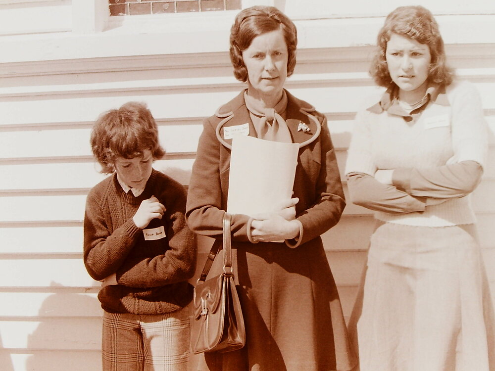 Women and boy standing outside church