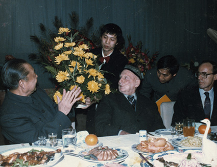 Flowers being presented to Rewi Alley at a banquet held to celebrate his 90th birthday, 1986.