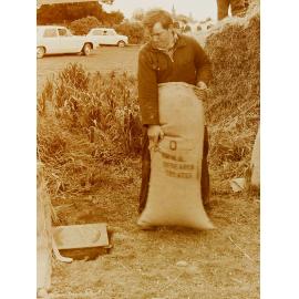 Man lifting a heavy sack