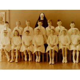 A Catholic nun with children at their first communion