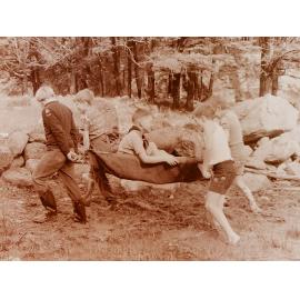Cub Scouts carrying boy on stretcher