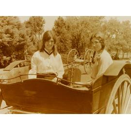 Women in costume in vintage vehicle