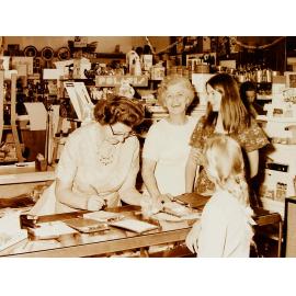 Women at shop counter in Farmers