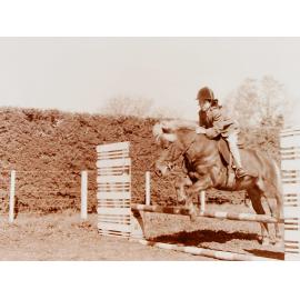 Girl and horse jumping at Show Jumping event