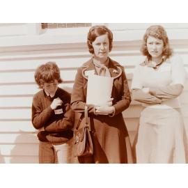 Women and boy standing outside church