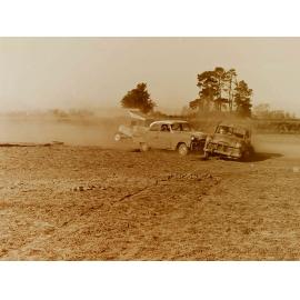 Cars colliding on dirt race track