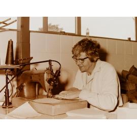Woman at sewing machine in clothing factory