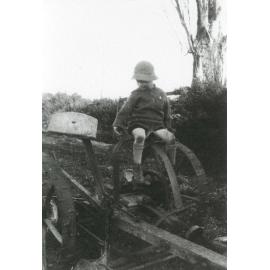 Young boy on McCormick horse mower