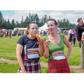 Two women eating Hororāta Pies at the Highland Games